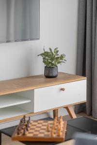 a chess board on a table next to a desk with a plant at Apartament Relax Rogowo Balkon & Parking by Noclegi Renters in Rogowo +28 photos