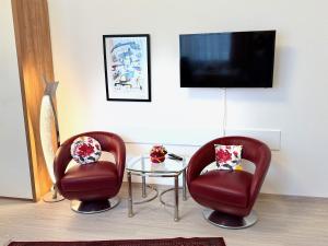 a room with two chairs and a table and a tv at Die Trauminsel 3 in Lindau