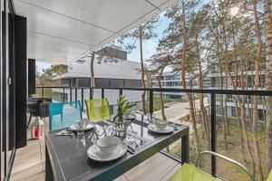 a dining table on the balcony of a house at Apartament Relax Rogowo Balkon & Parking by Noclegi Renters in Rogowo