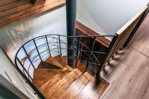 a wooden spiral staircase with a metal railing at Chata Margit - Margit-lak in Szalóc +17 photos