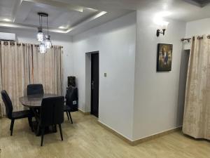 a dining room with a table and chairs at Feathers Apartments Abuja in Abuja