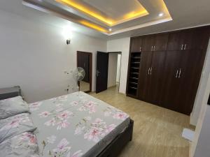a bedroom with a bed with pink flowers on it at Feathers Apartments Abuja in Abuja