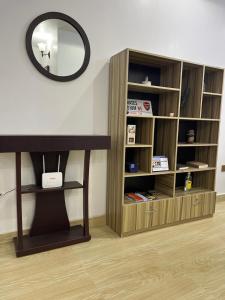 a book shelf with a mirror on a wall at Feathers Apartments Abuja in Abuja +2 photos