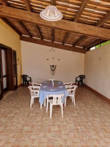 a dining room with a blue table and white chairs at Luna Marina Beach House in Marsala