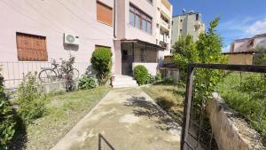 a walkway in front of a house with a fence at ARZO Apartments in Berat
