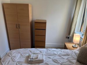 a bedroom with a bed with a dresser and a cabinet at jjkjs in London