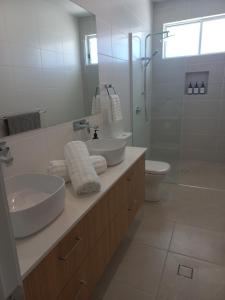 a white bathroom with two sinks and a shower at Lillian Waters Retreat in Yamba +25 photos