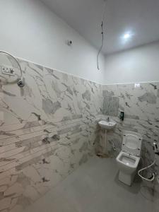 a bathroom with a toilet and a sink at Madhav Guest House in Mathura +3 photos