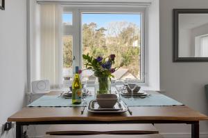ブリクサムにあるOur Happy Place- With Parking & Upgraded WiFi for 2025の花瓶と窓付きのダイニングテーブル