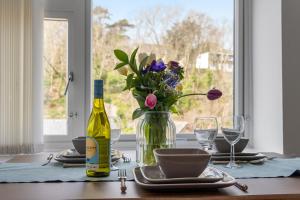 ブリクサムにあるOur Happy Place- With Parking & Upgraded WiFi for 2025のワイン一本と花瓶