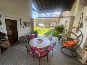 eine Terrasse mit Tisch und Stühlen in einem Gebäude in der Unterkunft Appartamenti con Giardino privato e vista Corte - Arena Po in Arena Po
