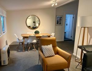 a living room with a table and a chair and a mirror at Fitzroy House - Federation charm near town centre in Cowra