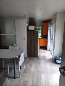 a kitchen and dining room with a table and a refrigerator at Camping de Salviac in Salviac