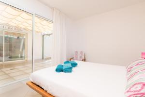 ein Schlafzimmer mit einem Bett mit blauen Handtüchern darauf in der Unterkunft Can Roig -Caldes- in Colònia de Sant Pere