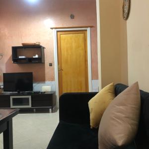 a living room with a couch and a tv at Typique AppartementVilla in Al Hoceïma