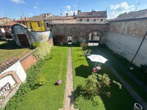 Eine Draufsicht auf einen Garten mit einem Regenschirm in der Unterkunft Appartamenti con Giardino privato e vista Corte - Arena Po in Arena Po