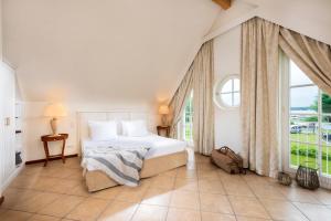 a bedroom with a bed and a large window at Sunday Schwielowsee Resort - Apartment in Werder