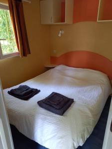 a bedroom with a bed with towels on it at Camping de Salviac in Salviac