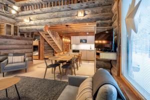 sala de estar con paredes de madera, mesa y sillas en Aurinkorinne, en Kuusamo