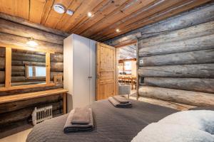 Un dormitorio con una cama en una habitación con paredes de madera. en Aurinkorinne, en Kuusamo