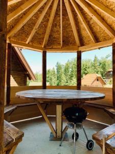 una gran mesa de madera en un pabellón con una silla en Nest&Rest-Vikendice Tara 2, en Sekulić 