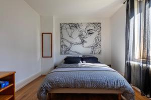 Un dormitorio con una cama y un cuadro en la pared. en Le Seventies - Proche de Montbéliard, en Valentigney