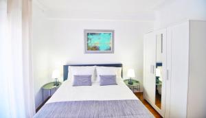a bedroom with a large bed with two lamps at Aomo-casa parede in Parede +100 photos