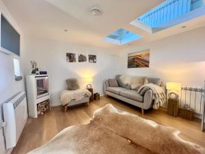 a living room with a couch and a tv at Little Barn Peak District in Leek