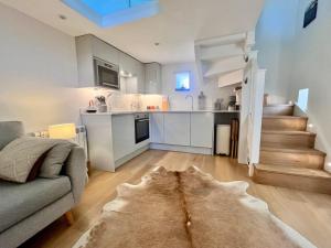 a living room with a couch and a kitchen at Little Barn Peak District in Leek