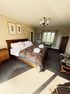 a bedroom with a large bed in a room at Elms Farm Cottages - White Swans in Icklesham