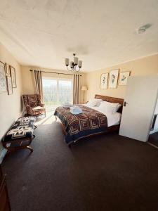 a bedroom with a bed and a large window at Elms Farm Cottages - White Swans in Icklesham