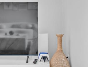 塔扎纳High Ceilings 3BR with Loft-2 Baths Pool & Jacuzzi的坐在电视旁边的桌子上的花瓶
