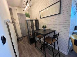 a black table and chairs in a room with a wall at Studio proche gare centre ville au calme côté cour in Orléans +4 photos