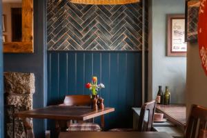 a dining room with a table and a blue wall at The Old Success Inn in Sennen Cove
