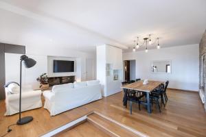 soggiorno e sala da pranzo con mobili bianchi e tavolo di Villa Piscina La Trinità a Corciano