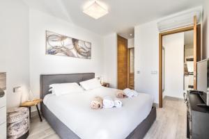 a bedroom with a large white bed with towels on it at Colinas - Timanfaya 03 VISTA RESERVA NATURAL Y JARDIN in Palm-mar +15 photos