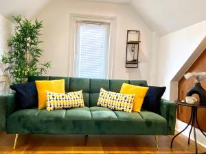 a green couch with yellow pillows in a living room at Pinnacle Apartment in Reading
