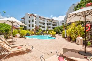 a resort with a pool and chairs and a building at Colinas - Timanfaya 03 VISTA RESERVA NATURAL Y JARDIN in Palm-mar