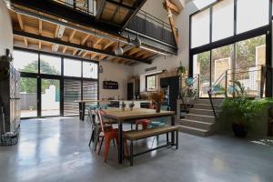a living room with a table and chairs and a staircase at Le Loft Nantais - Superbe Loft de 300m² in Nantes