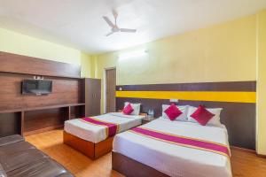 a hotel room with two beds and a tv at OYO 825 Hotel Baikuntha in Kathmandu