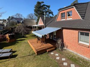 Neuhausにある-"Ferienwohnung Dierhagen" Whg 1 im EG-の青い日よけ付きのポーチ付きの家