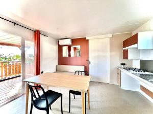 a kitchen with a wooden table and chairs in a room at Camping Village Tuscia Tirrenica in Tarquinia