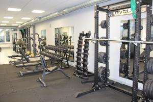 a gym with rows of squat racks and weights at Ignalinos sporto ir pramogų centras in Ignalina