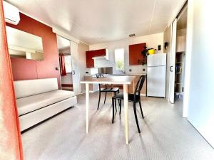 a kitchen and dining room with a table and a refrigerator at Camping Village Tuscia Tirrenica in Tarquinia