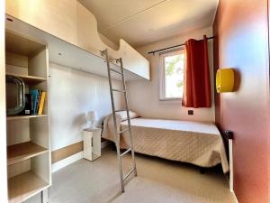 a small bedroom with a bunk bed and a ladder at Camping Village Tuscia Tirrenica in Tarquinia