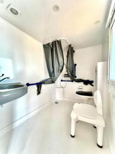 a white bathroom with a sink and a toilet at Camping Village Tuscia Tirrenica in Tarquinia
