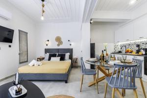 a bedroom with a bed and a table and chairs at VRACHOS HOUSE "In the heart of Skopelos Town" in Skopelos Town