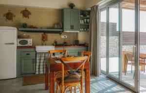 a kitchen with green cabinets and a table and chairs at Ammoo in Amoopi