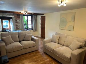 a living room with two couches and a bed at Knockerdown Cottages in Ashbourne