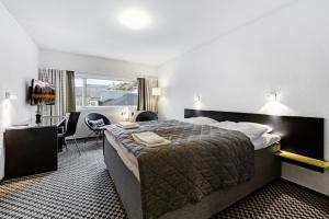 a hotel room with a large bed and a desk at Hotel Thisted in Thisted